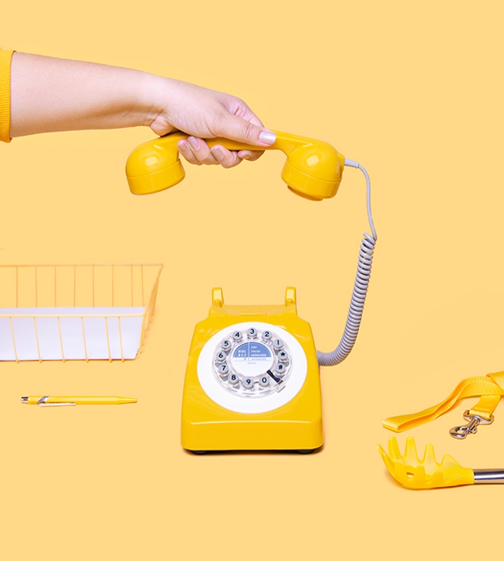 Hand picking up yellow phone